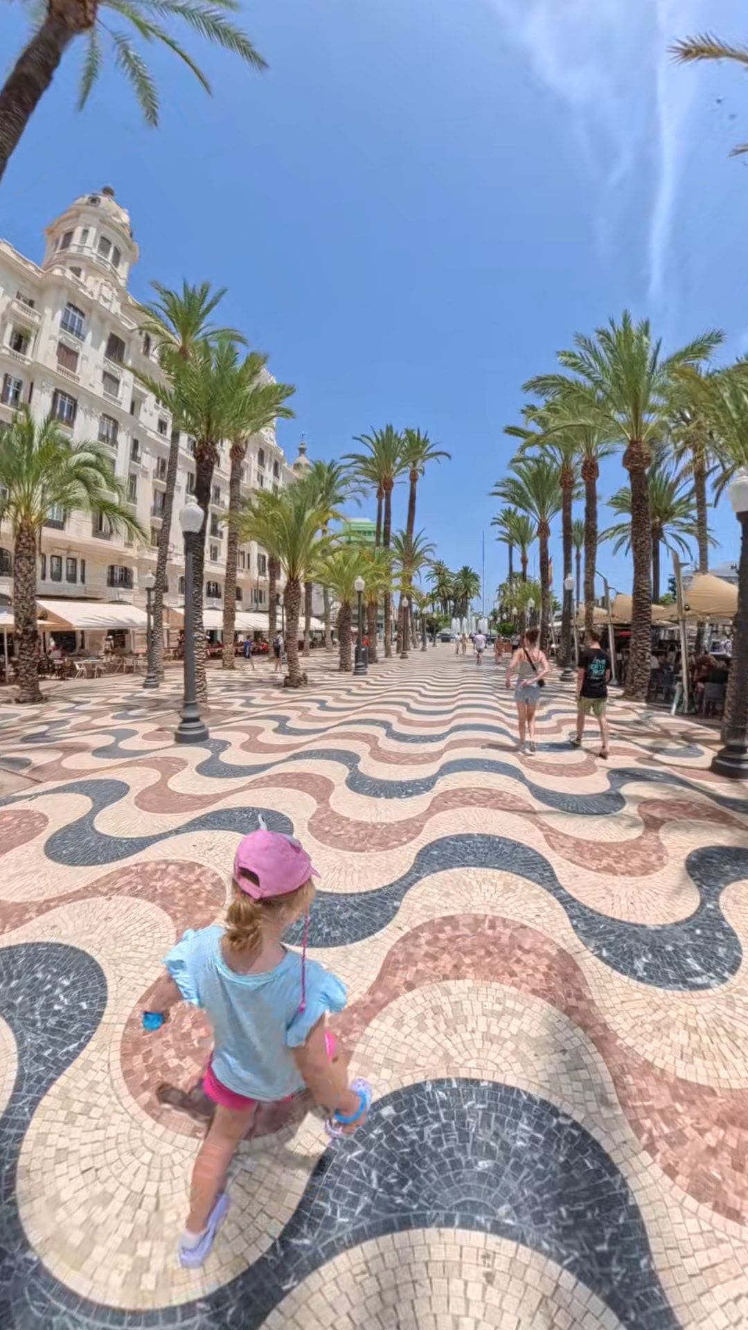 Our daughter running along the wave-patterned mosaic of the Explanada de España in Alicante