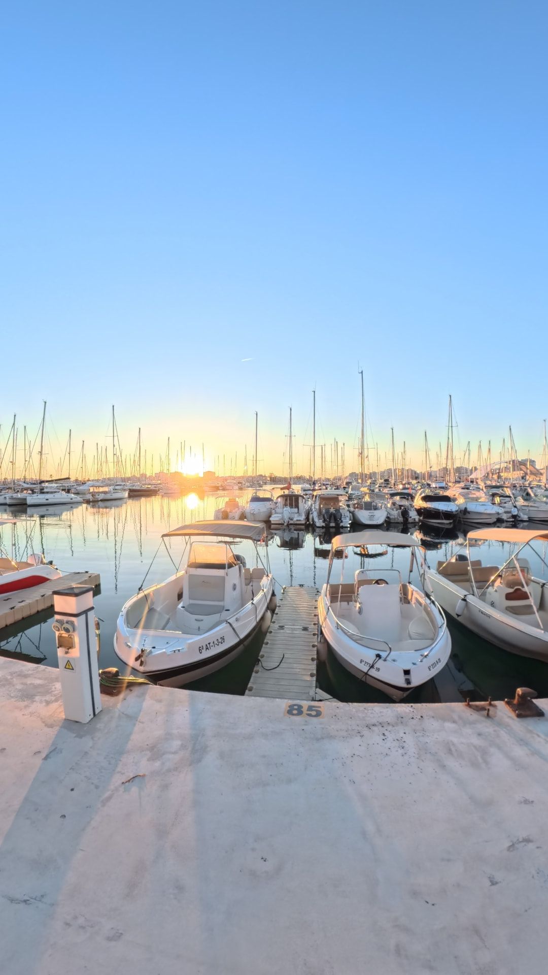 Boats moored on the pontoons of a Costa Blanca marina at sunset