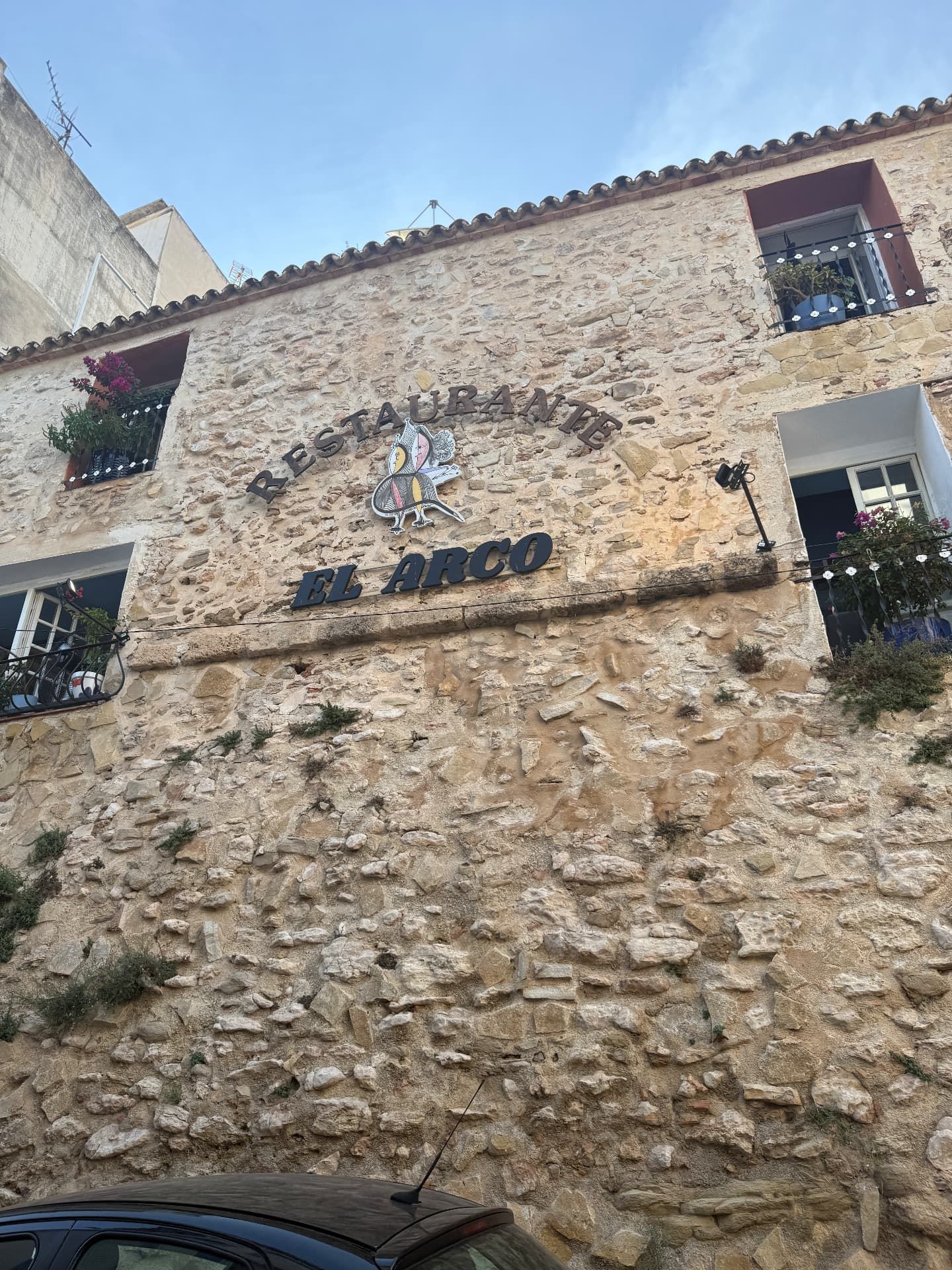 The stone facade and sign of Restaurante El Arco in Calpe old town