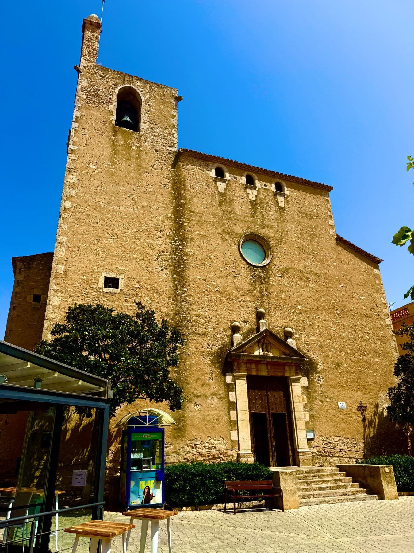 The stone church and bell tower on the square of a Costa Brava village