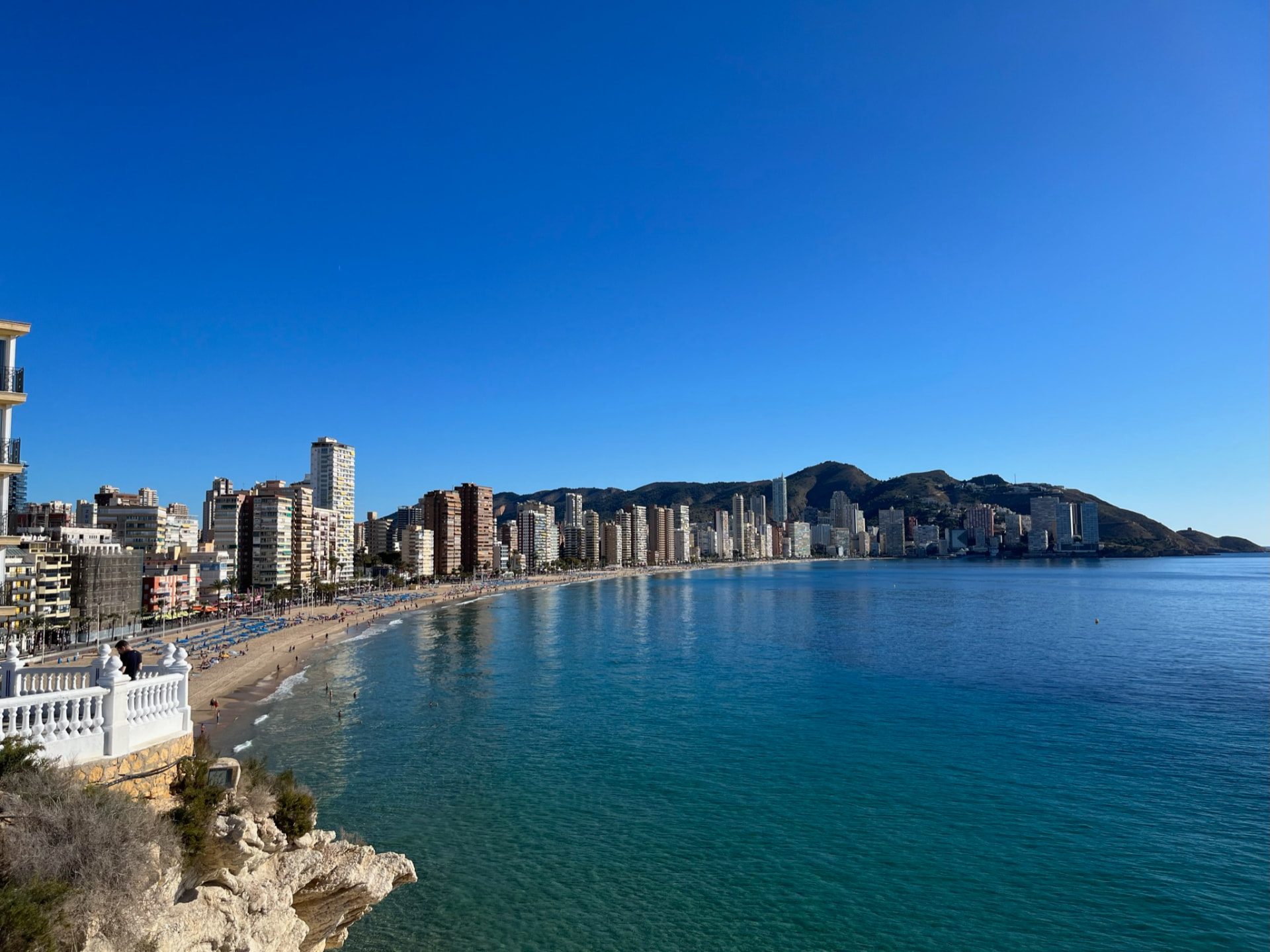 Levante beach and the Benidorm skyline curving around the bay seen from the headland